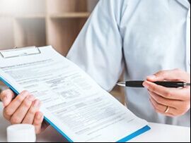 Close up of person filling out an insurance form.