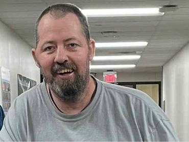 Erik smiling at the camera in a hallway