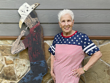 Linda Bomar stands next to cowboy yard art at her home.