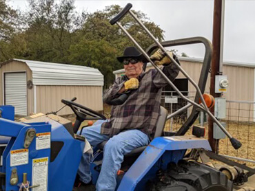 Richard Andrews drives his tractor following rehabilitation.